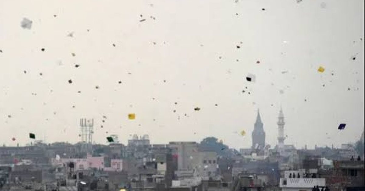 A Lahore sky dense with kites over the rooftops in the middle of the afternoon