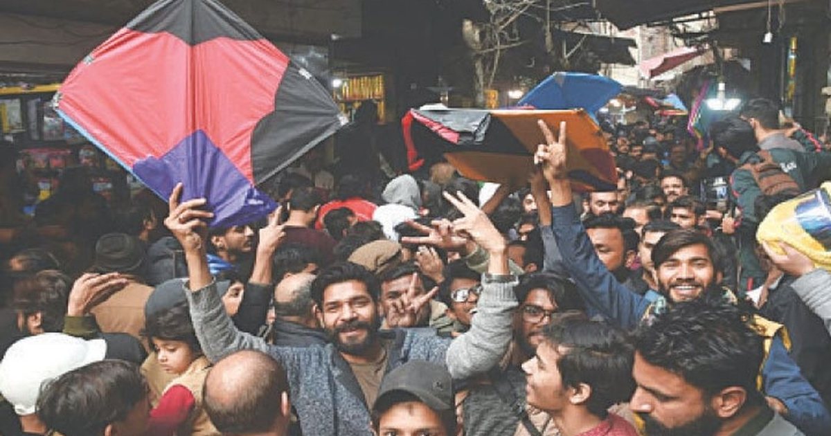 A crowded kite bazaar in Lahore, kites held up above the stalls