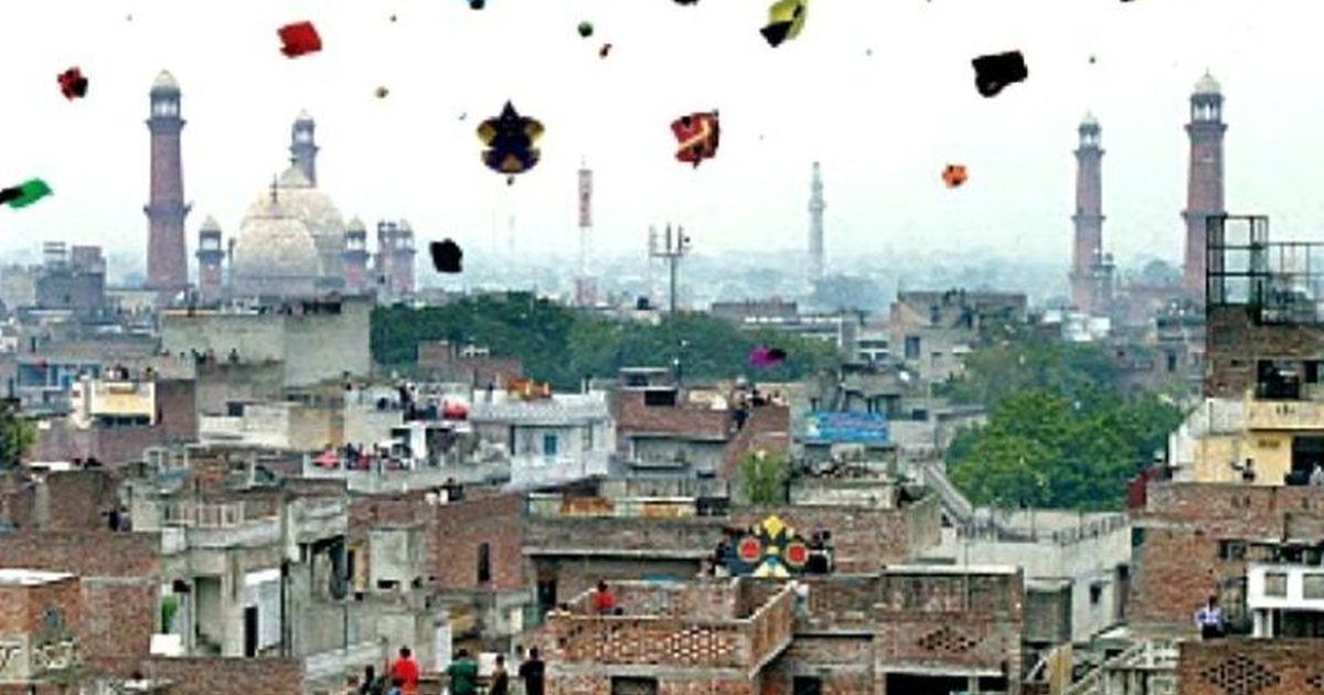 Kites above the rooftops of the Walled City with the minarets of the Badshahi Mosque behind